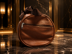 A brown textured leather circular bag with a top zipper and a dark brown ribbon handle, set on a polished black marble floor with gold-framed walls in the background.